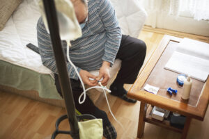 Man connecting peritoneal dialysis with catheter at home