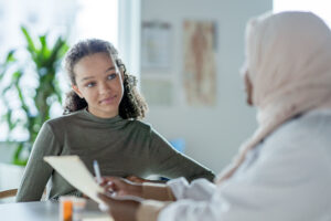 A young person consulting wit h a female Muslim doctor