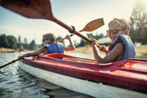 Two young children enjoying kayaking on watre